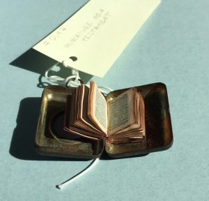 View of miniature Bible published by Frederick A. Stokes in New York in 189?, with item open inside its metal carrying case