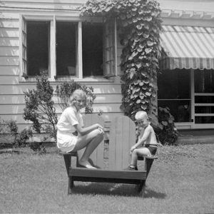 Elise and Harry Brandt Ayers sitting on the arms of a lawn chair, late 1930s